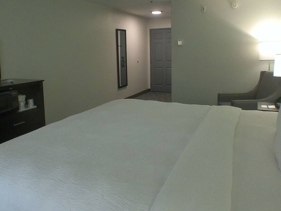 A hotel room with a bed, a TV, a desk, and a chair.
