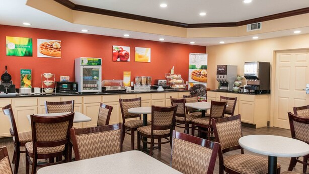 Un restaurante con mostrador, mesas y diferentes exhibiciones de comida.