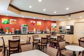 A restaurant with a counter, seating, and various food displays. - Quality Inn & Suites Houma (Houma)