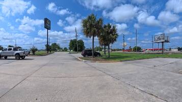 A parking lot with a Quality Inn sign, palm trees, and a McDonald's in the background.