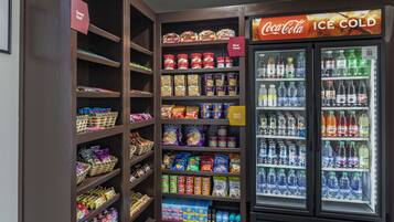A vending machine stocked with various snacks and beverages, including ice cold Coca-Cola.