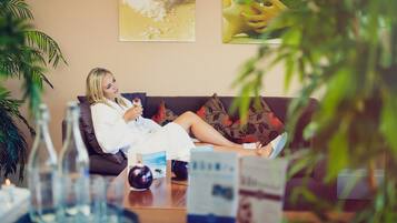 Relax in style with a comfortable sofa, elegant artwork, and a serene atmosphere.