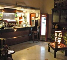 Angolo bar con frigorifero, sgabelli da bar e una pianta in vaso.