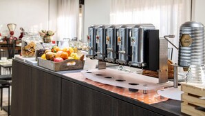 Una barra de desayuno con una exhibición de frutas, máquinas de café y un molinillo.