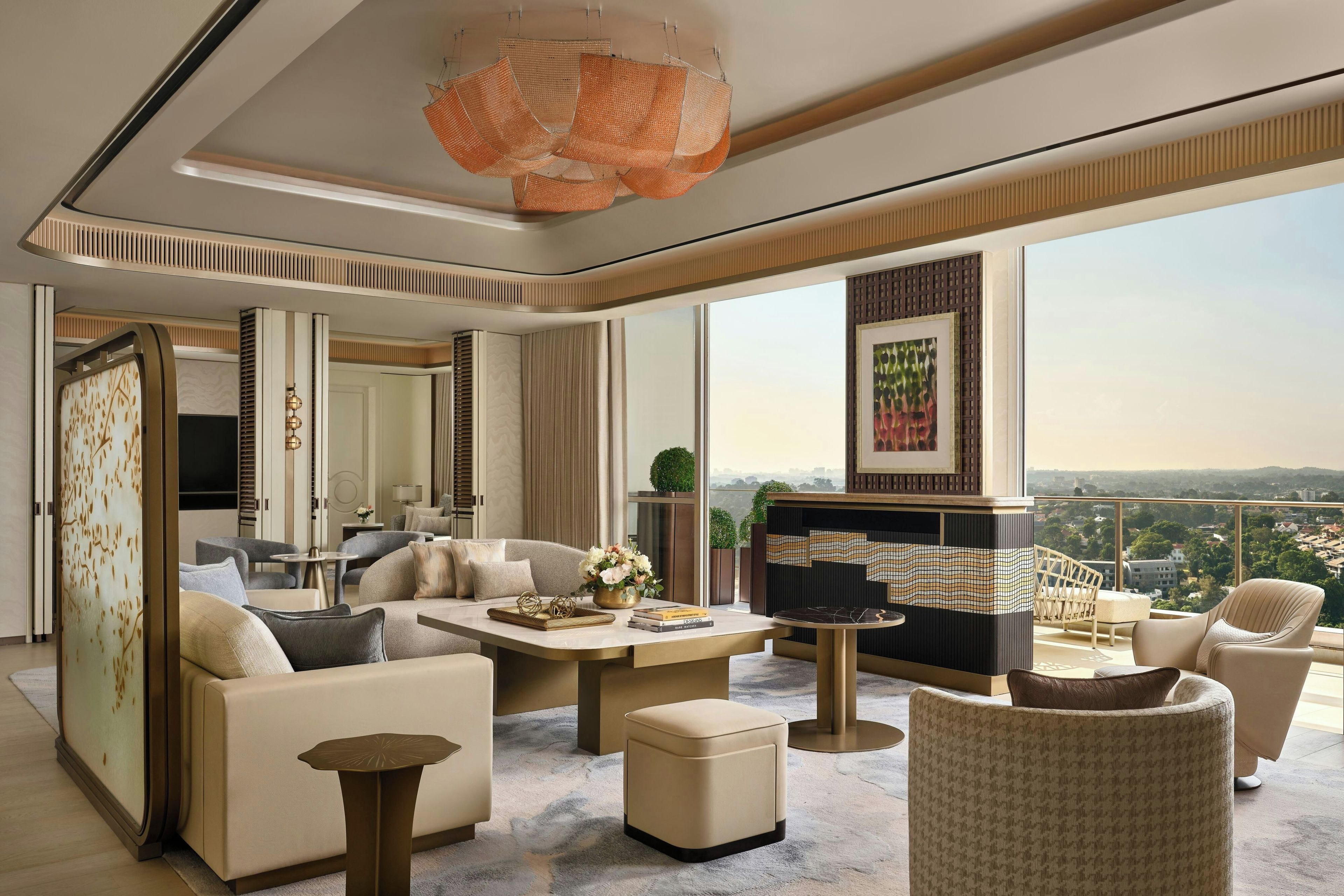 Una sala de estar moderna con un conjunto de sofás, una mesa de centro y un televisor. Hay un balcón con vistas a la ciudad.