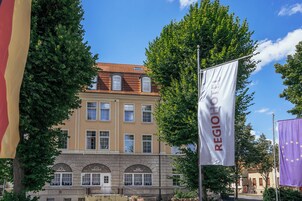Ein Gebäude im klassischen Stil, mit einem Ziegeldach und gewölbten Fenstern.