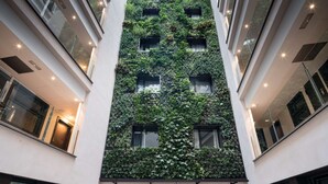 A modern building with a vertical garden facade, multiple balconies, and large windows. - Catalonia Avinyó (Barcelona)
