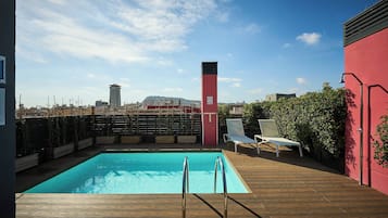 Alberca al aire libre y camastros