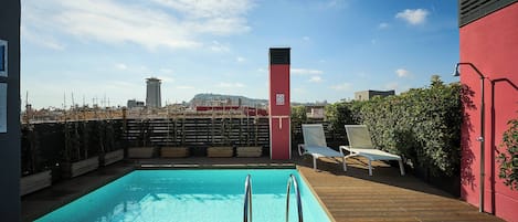 Een buitenzwembad en ligstoelen