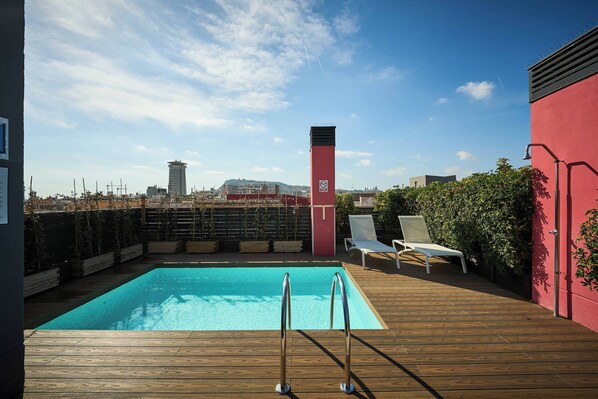 Een buitenzwembad en ligstoelen