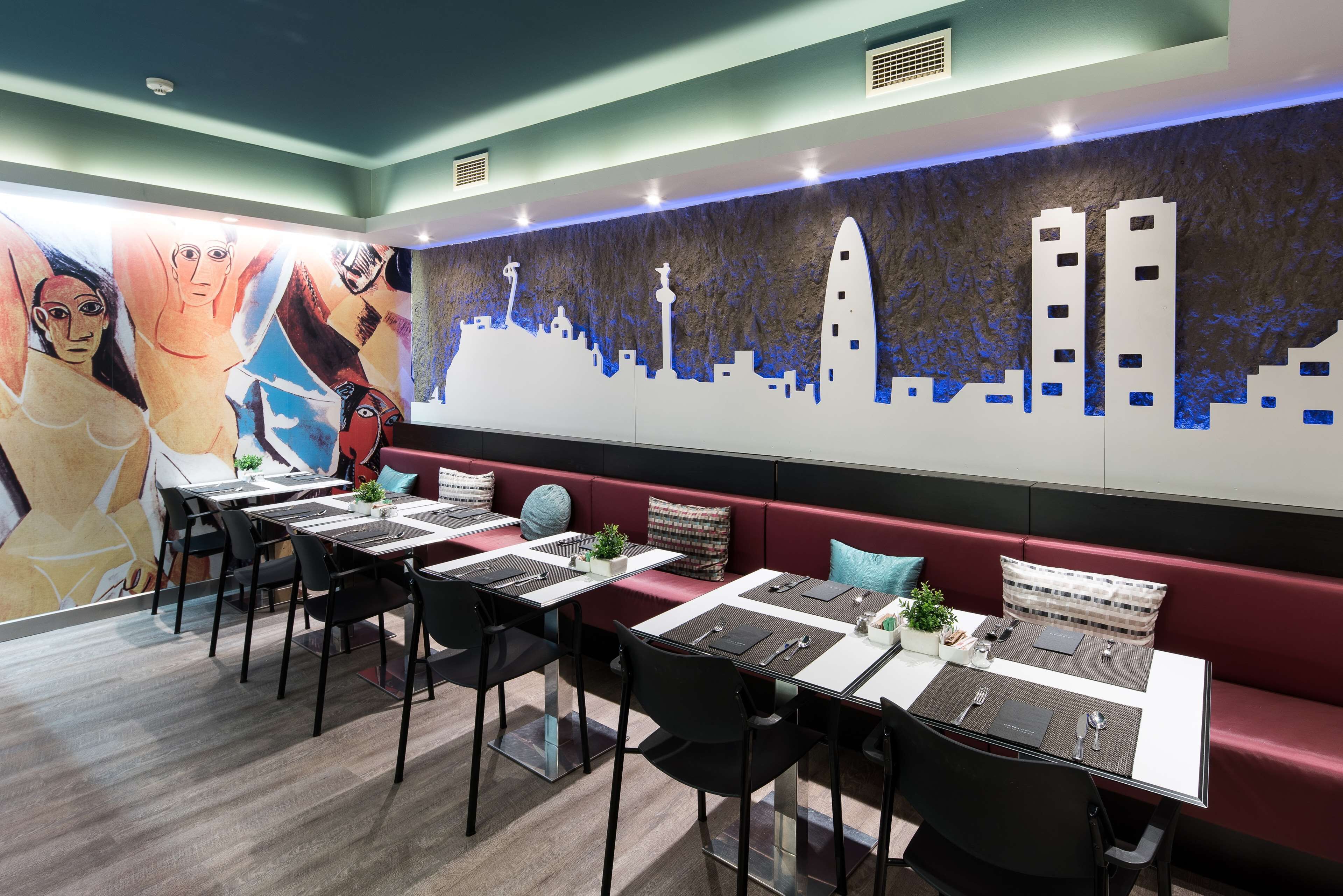 A dining area with tables, chairs, and a mural on the wall.