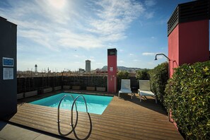 Een buitenzwembad en ligstoelen