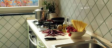 Uma cozinha com janela, pia e fogão.