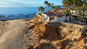 A coastal property with a sandy beach, palm trees, and a view of the sea. - Hotel Punta Pescadero Paradise (Los Barriles)
