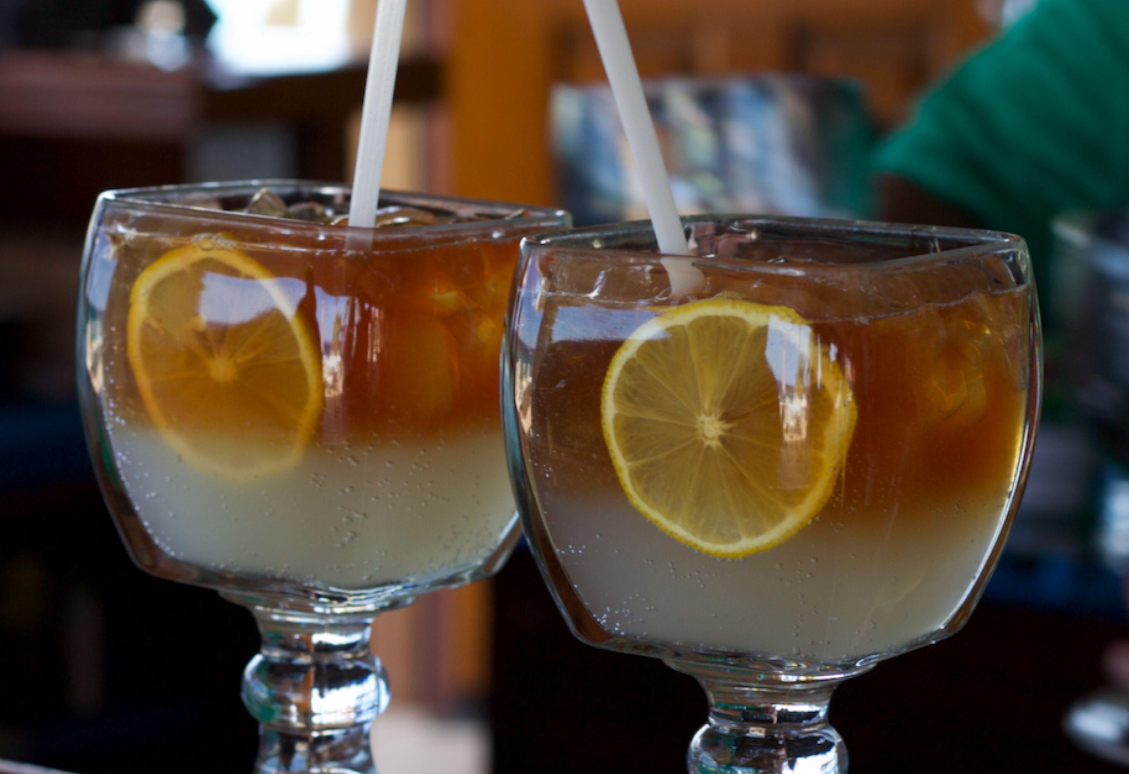 Deux verres de thé glacé, avec des rondelles de citron et des pailles.