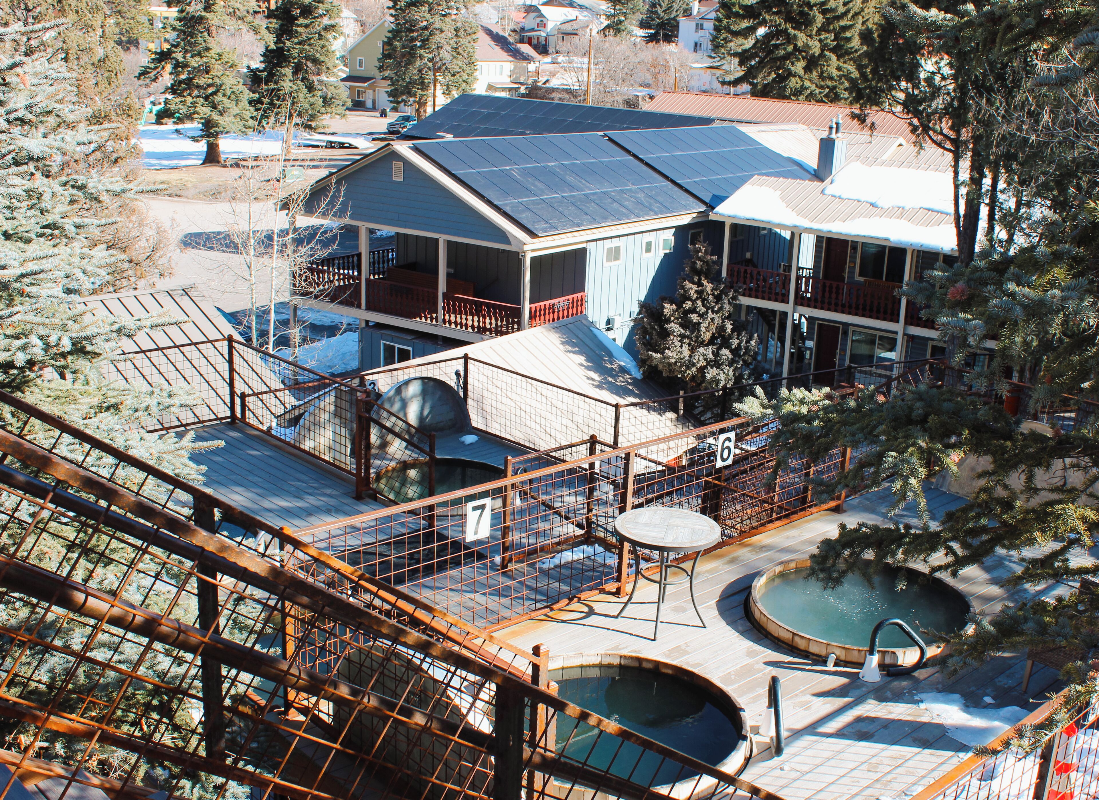 A house with solar panels, a pool, and a staircase.