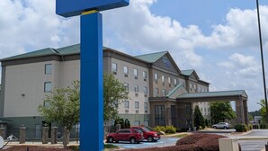 A Sonesta Essential Hotels building with a blue sign, a parking lot, and a red car. - Sonesta Essential Columbus (Columbus)
