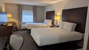 A hotel room with two beds, a desk, a chair, and a window with curtains. - Sonesta Essential Columbus (Columbus)