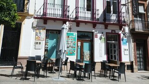 A building with a sign reading "hostal San Cevetano 113" and outdoor seating with tables and chairs. - Hostal San Cayetano (Ronda)