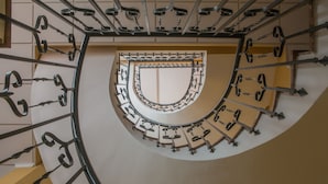 A spiral staircase with metal railings and a central open area. - Hostal San Cayetano (Ronda)