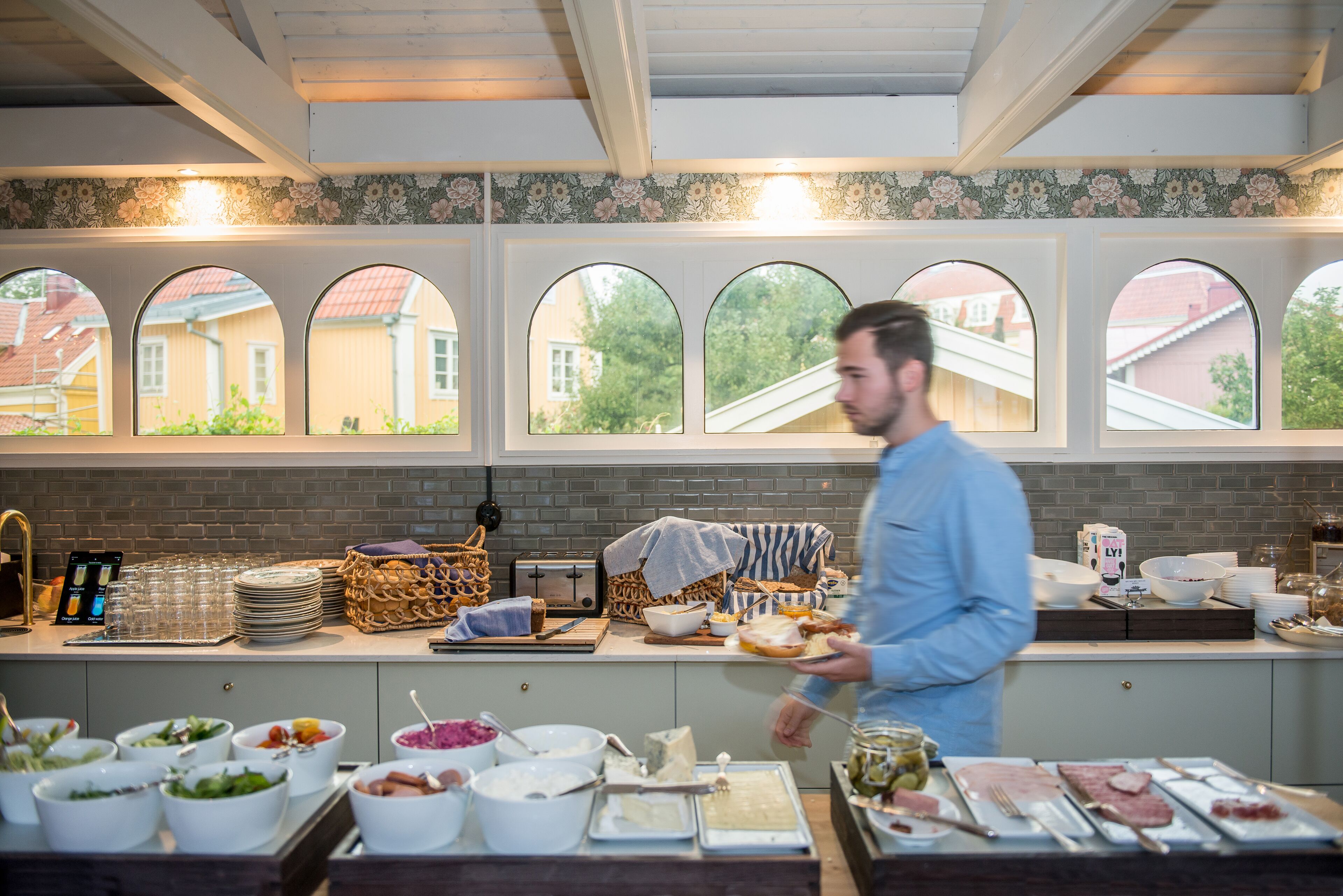 Una mesa de buffet con diferentes platillos y una persona sirviendo.