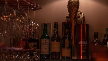 En bardisk med ett stort utbud av spritflaskor och glas.