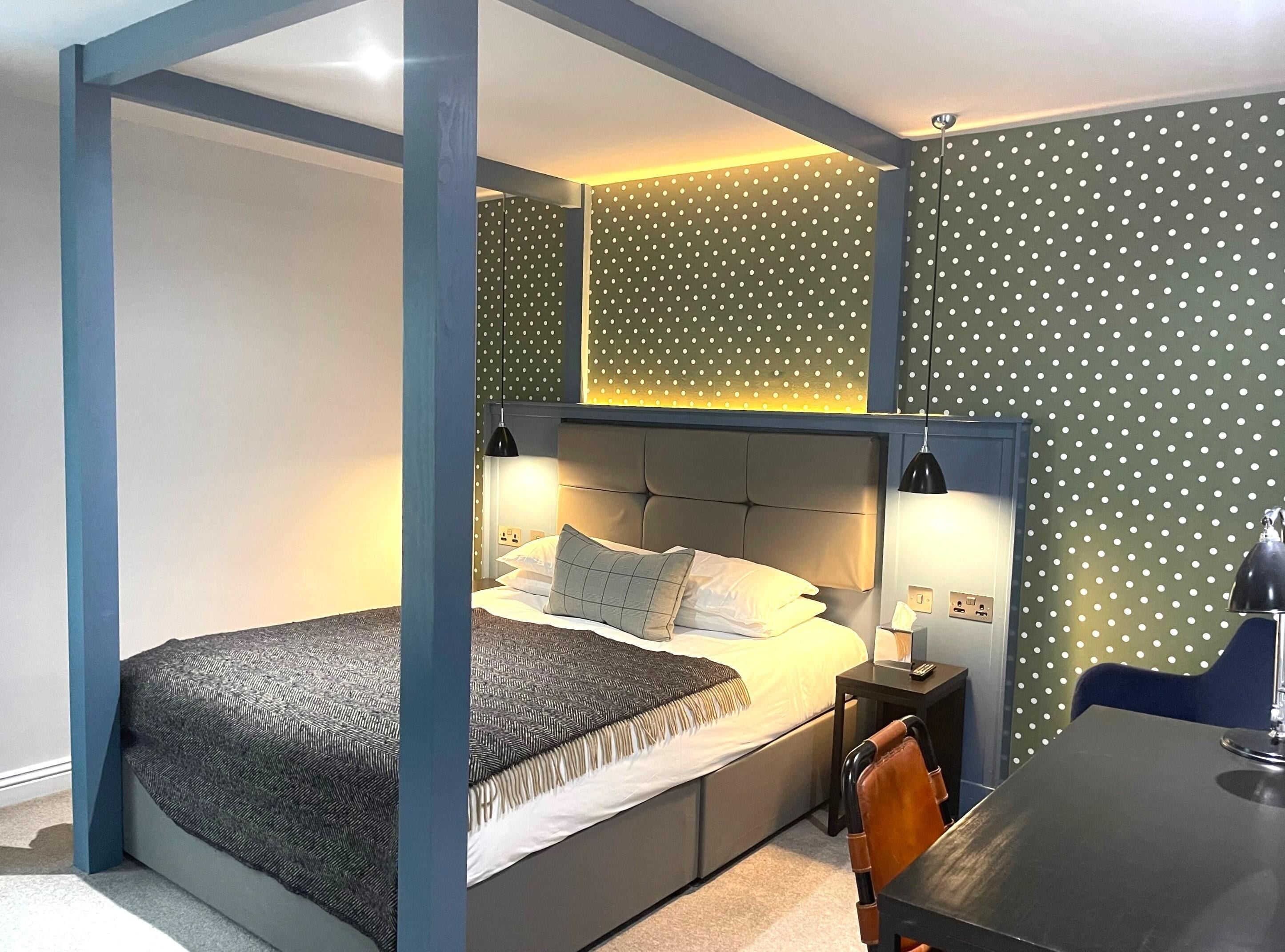 A modern bedroom with a bed, bedside tables, and a desk.