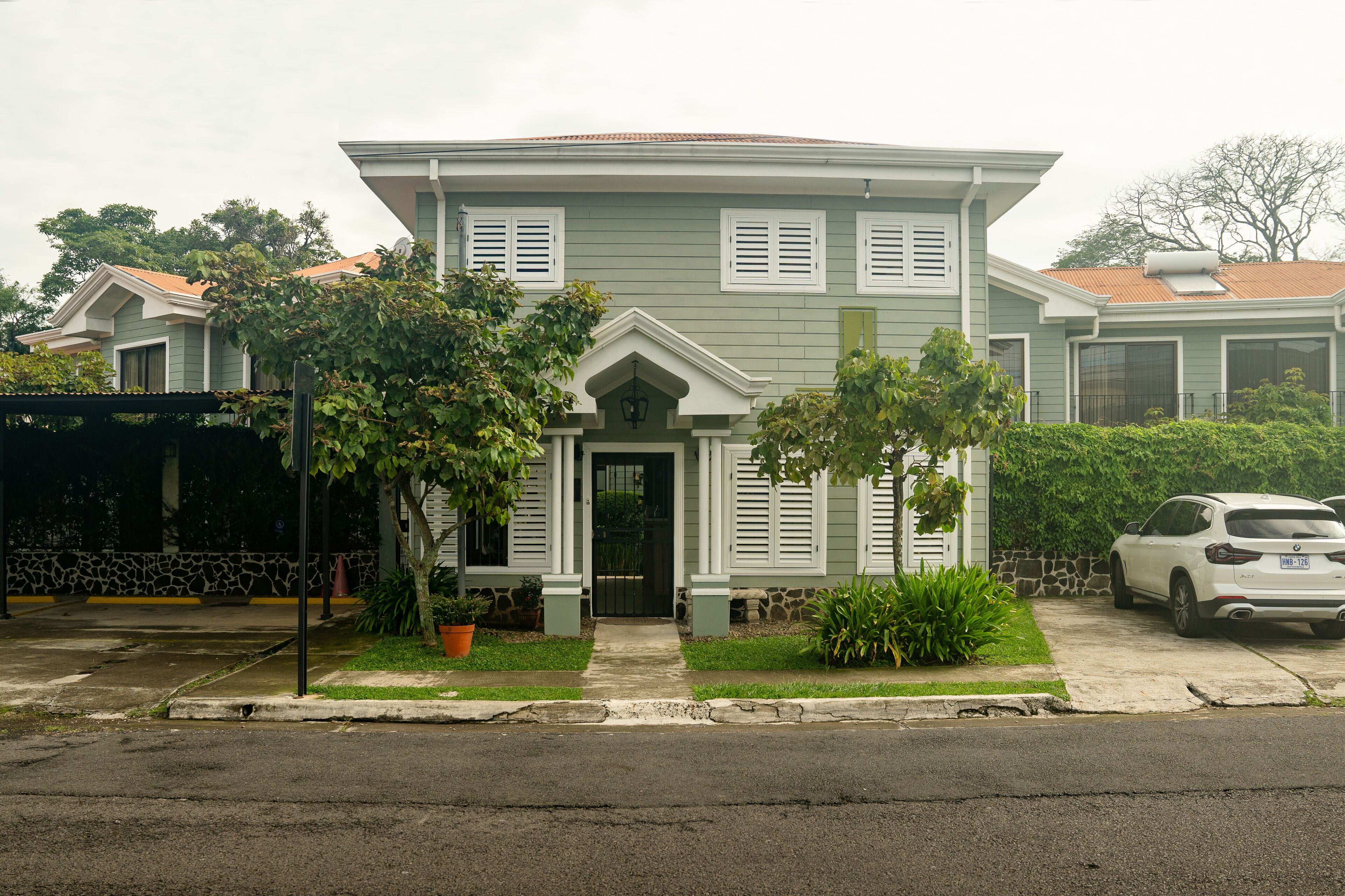 A two-story house with a front porch, a garage, and a driveway.