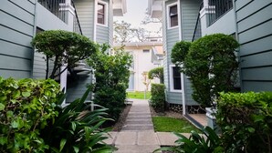 A narrow pathway flanked by two-story buildings with balconies, leading to a central door. - Hotel Villa Los Candiles (Santa Ana)