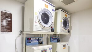 A laundry facility with two front-loading washing machines and two coin-operated dryers. - Comfort Hotel Shin Yamaguchi (Yamaguchi)