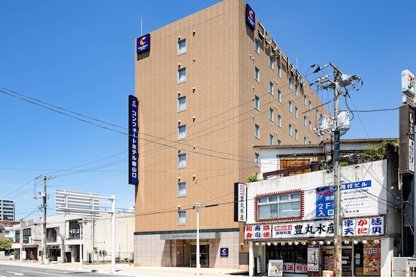 A hotel with multiple floors, a prominent sign, and a storefront with various signs.