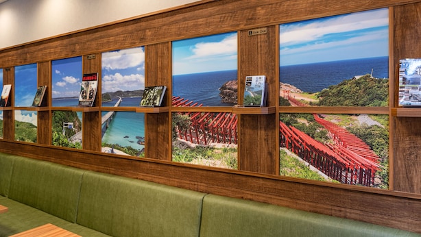 A row of framed photographs on a wooden shelf, each depicting different coastal scenes. - Comfort Hotel Shin Yamaguchi (Yamaguchi)