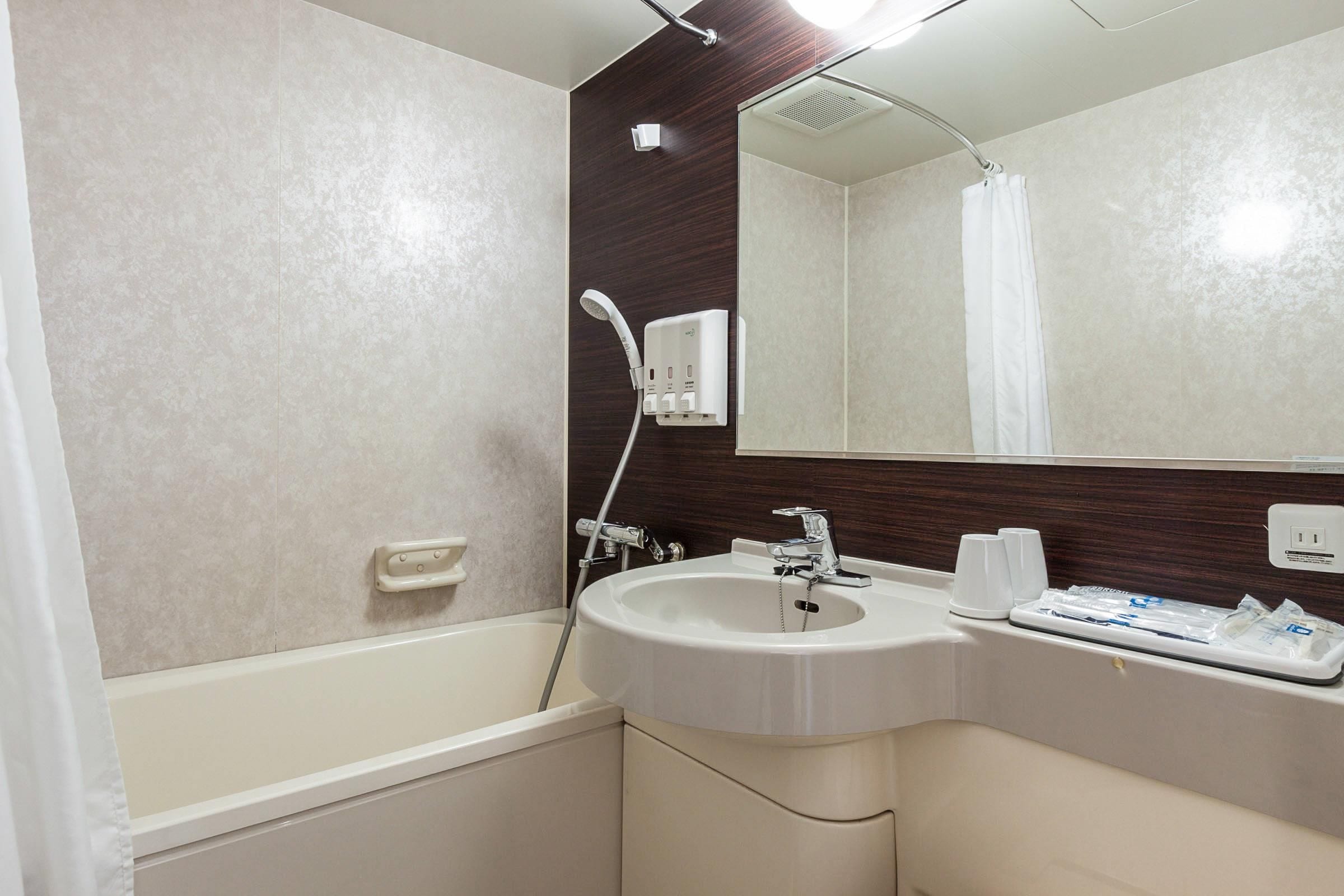 A modern bathroom with a bathtub, a sink, and a mirror.