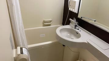 Un bagno con lavandino bianco, uno specchio, un portascopevoli e un water.