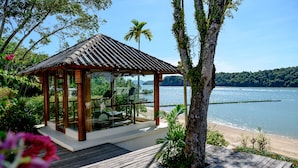 A wooden gazebo with a glass enclosure overlooking a beach and water. - Chandara Resort & Spa Phuket (Pa Klok)