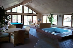 A spacious indoor area with a pool table, lounge chairs, and a hot tub. - Ridgecrest Condominiums by Pioneer Ridge Management (Steamboat Springs)