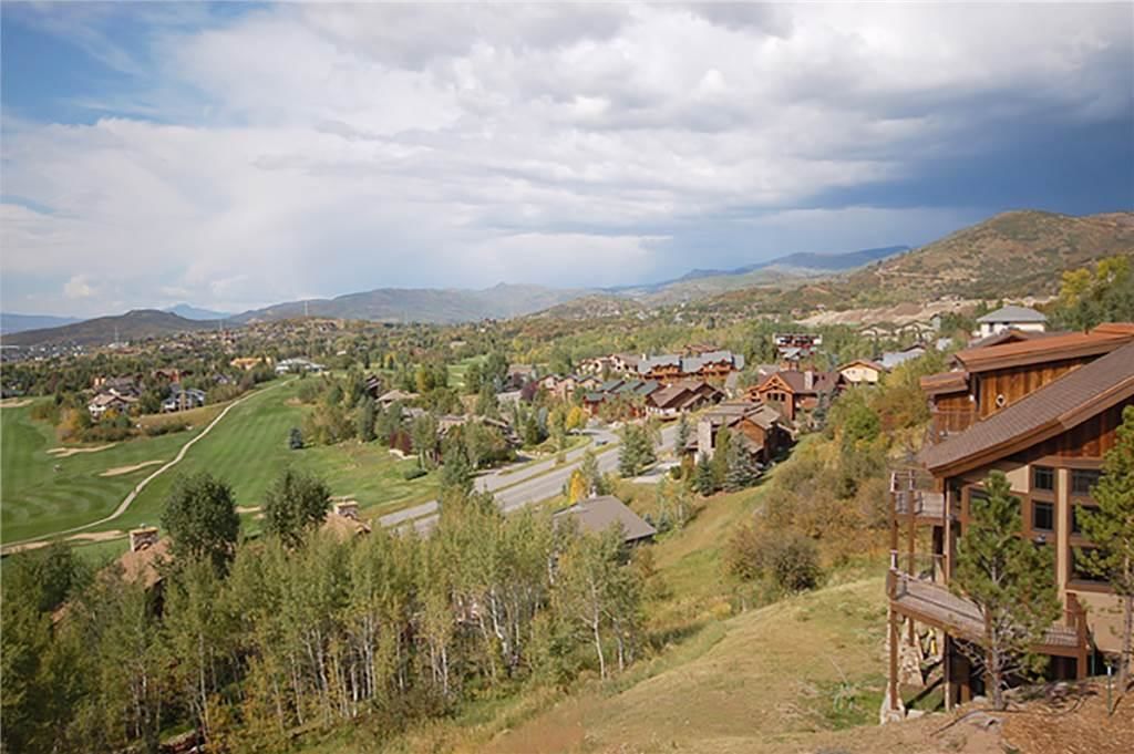 Un quartier résidentiel avec des maisons, un terrain de golf et un paysage montagneux en arrière-plan.