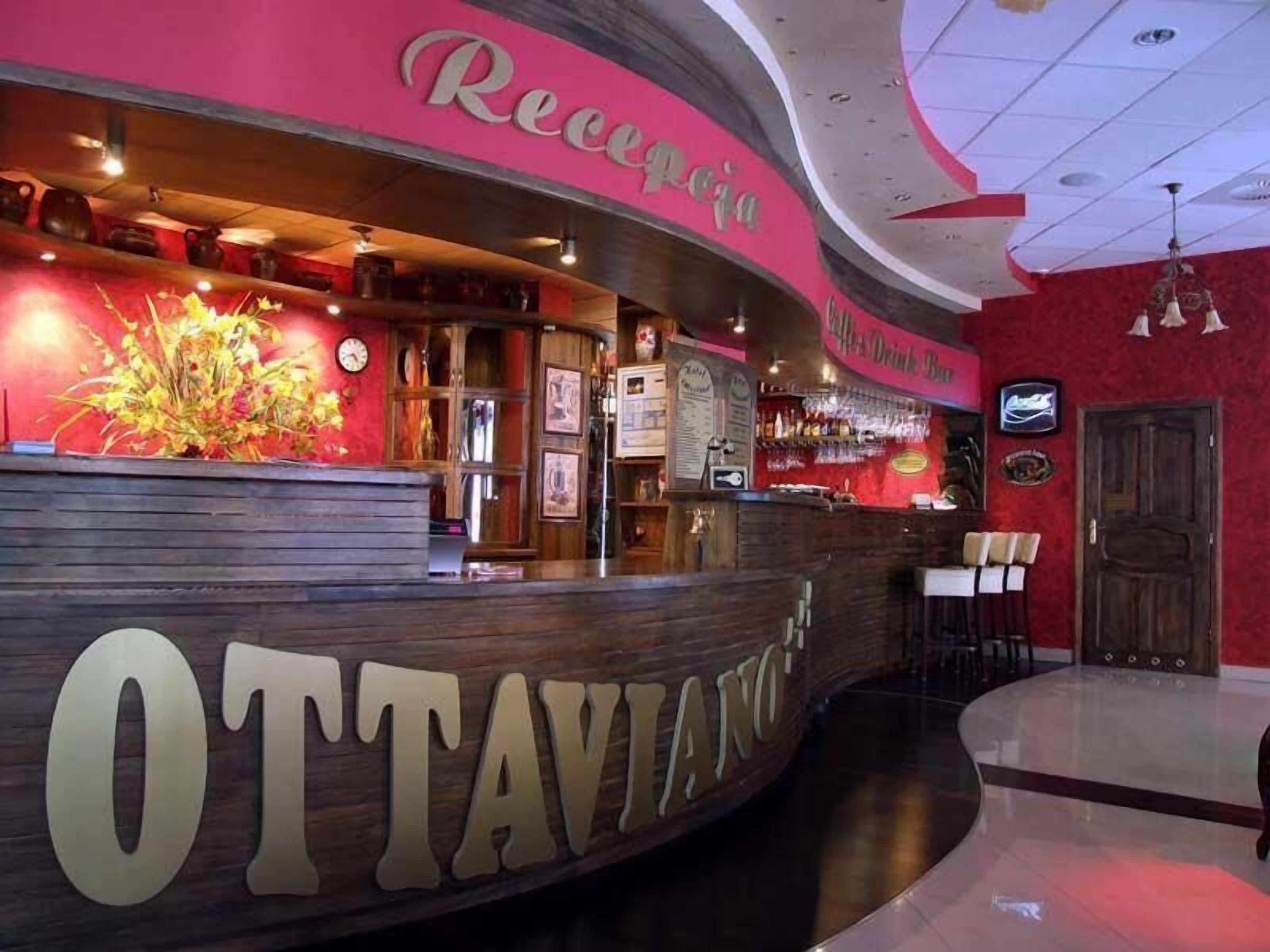 A reception area with a curved counter, a clock, and a menu board.