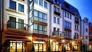 Un hotel con varios balcones, ventanas amplias y una fachada bien iluminada.