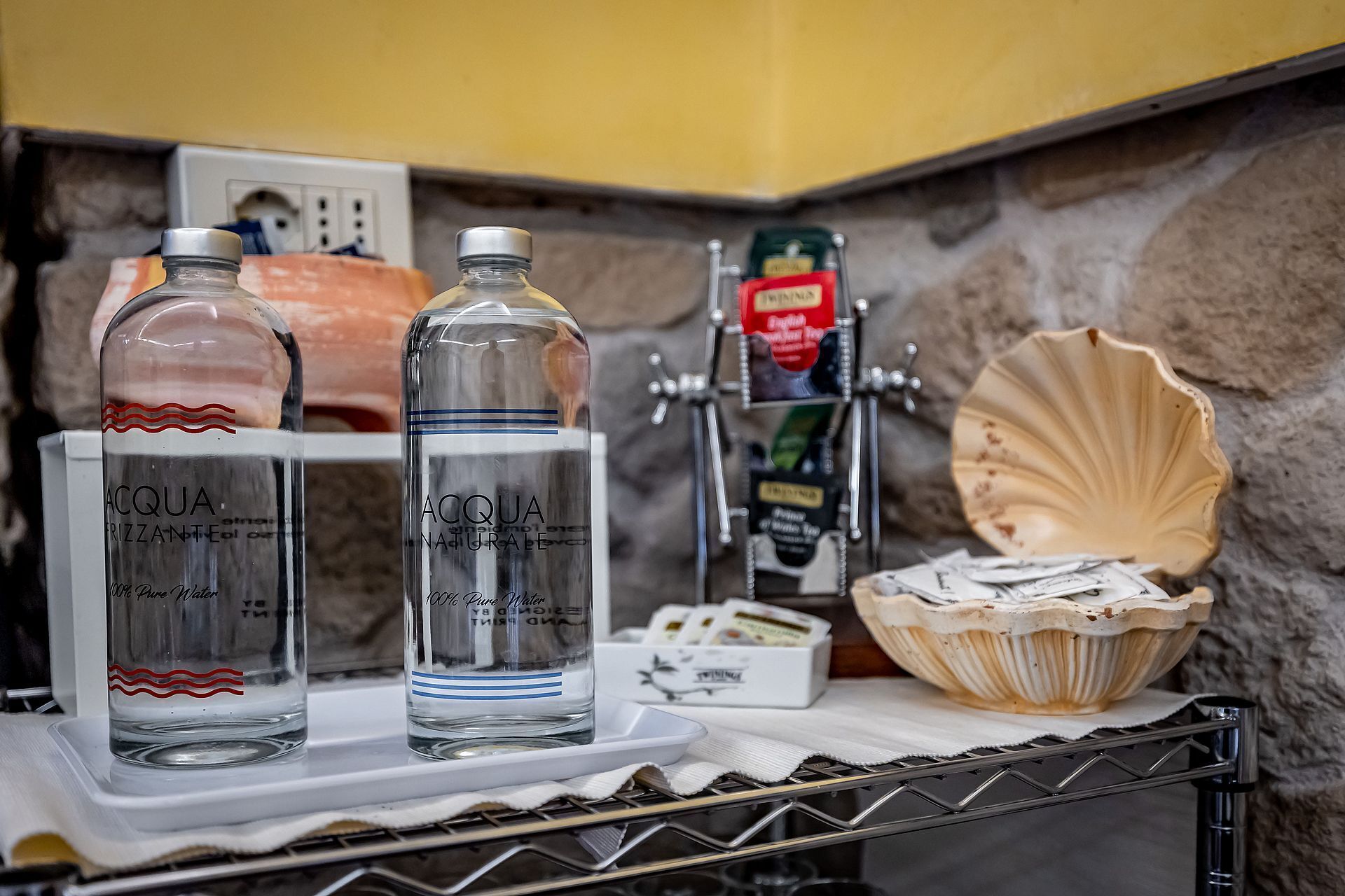 Two bottles of Acqua, a seafood display, and a seafood basket on a counter.