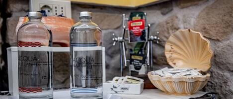 Two bottles of Acqua, a seafood display, and a seafood basket on a counter.