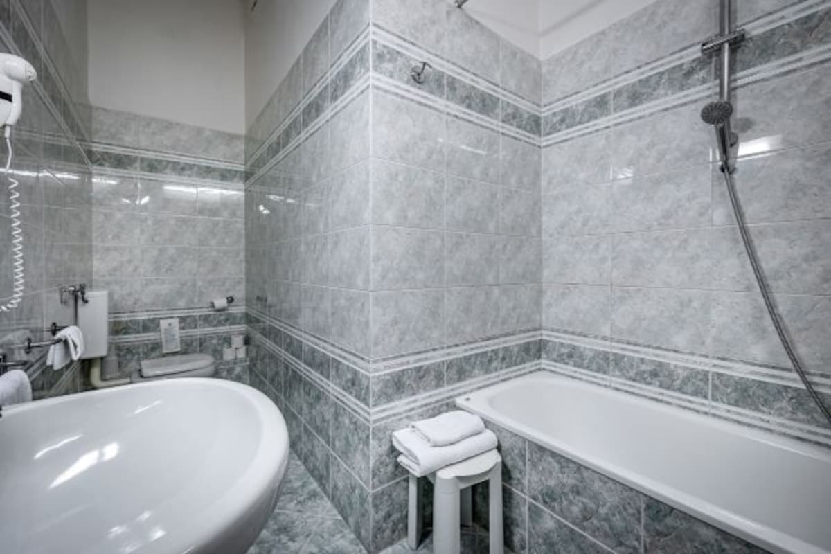 A bathroom with a large sink, a bathtub, and a shower.