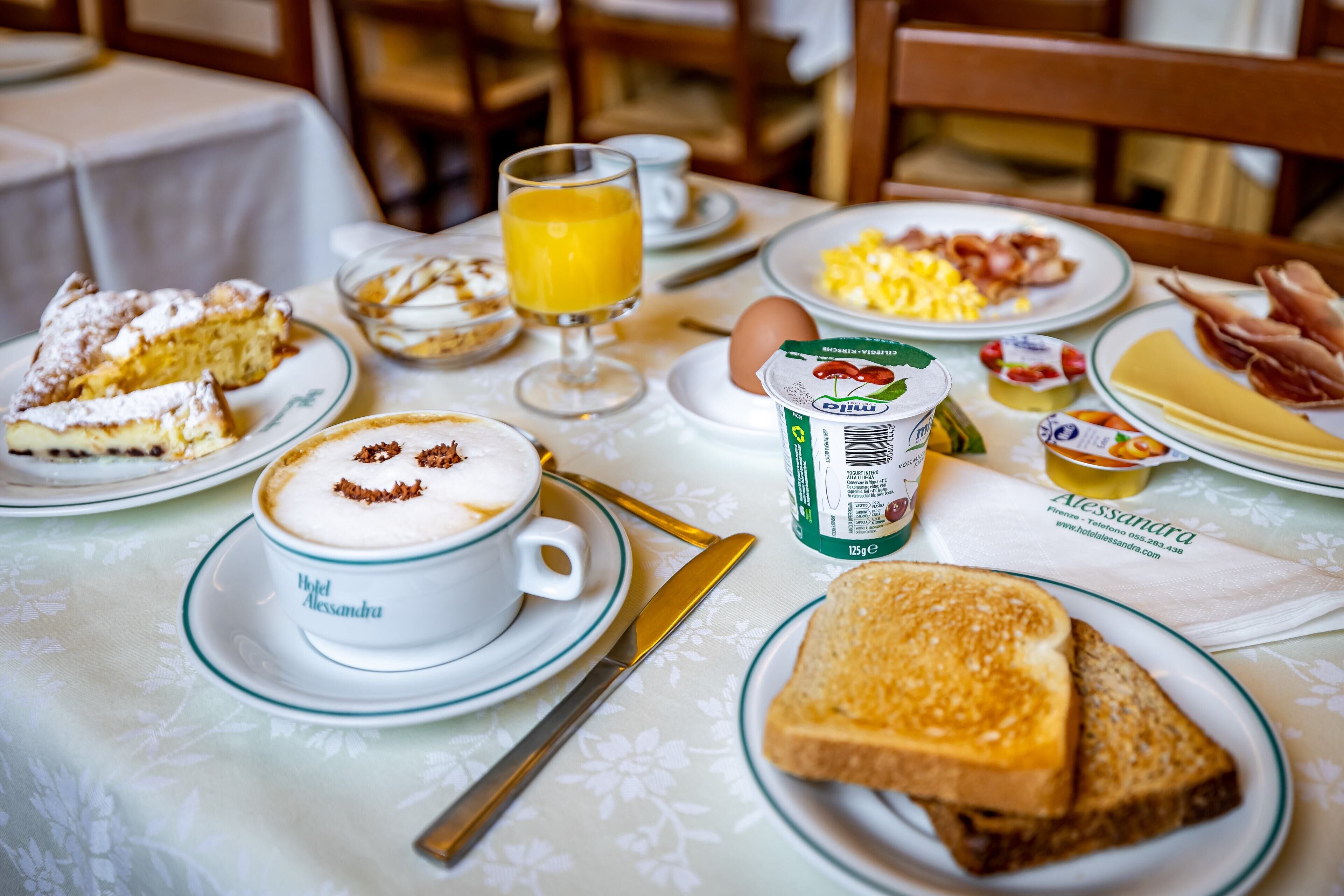 A breakfast table with a variety of food items including toast, eggs, and a coffee cup.