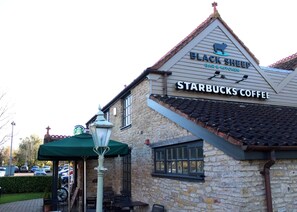 Un bâtiment sur lequel on peut voir une enseigne indiquant « Black Sheep Bar & Kitchen » et « Starbucks Coffee ».