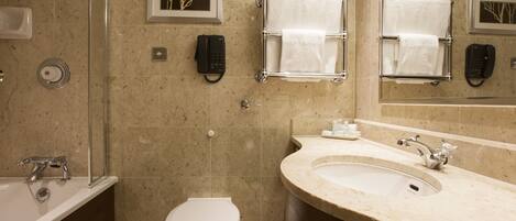A bathroom with a bathtub, toilet, sink, and a glass shower enclosure.