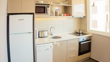 Una cocina moderna con lavavajillas Bosch, microondas, pileta y estufa.