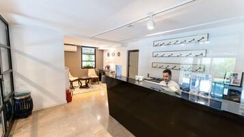 A reception area with a black counter, a man at the desk, and a wall with key displays.