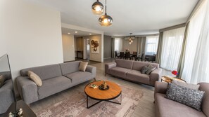 Apartamento, 3 habitaciones, vistas a la ciudad | Zona de estar | Televisión LED de 55 pulgadas con canales digitales, una televisión