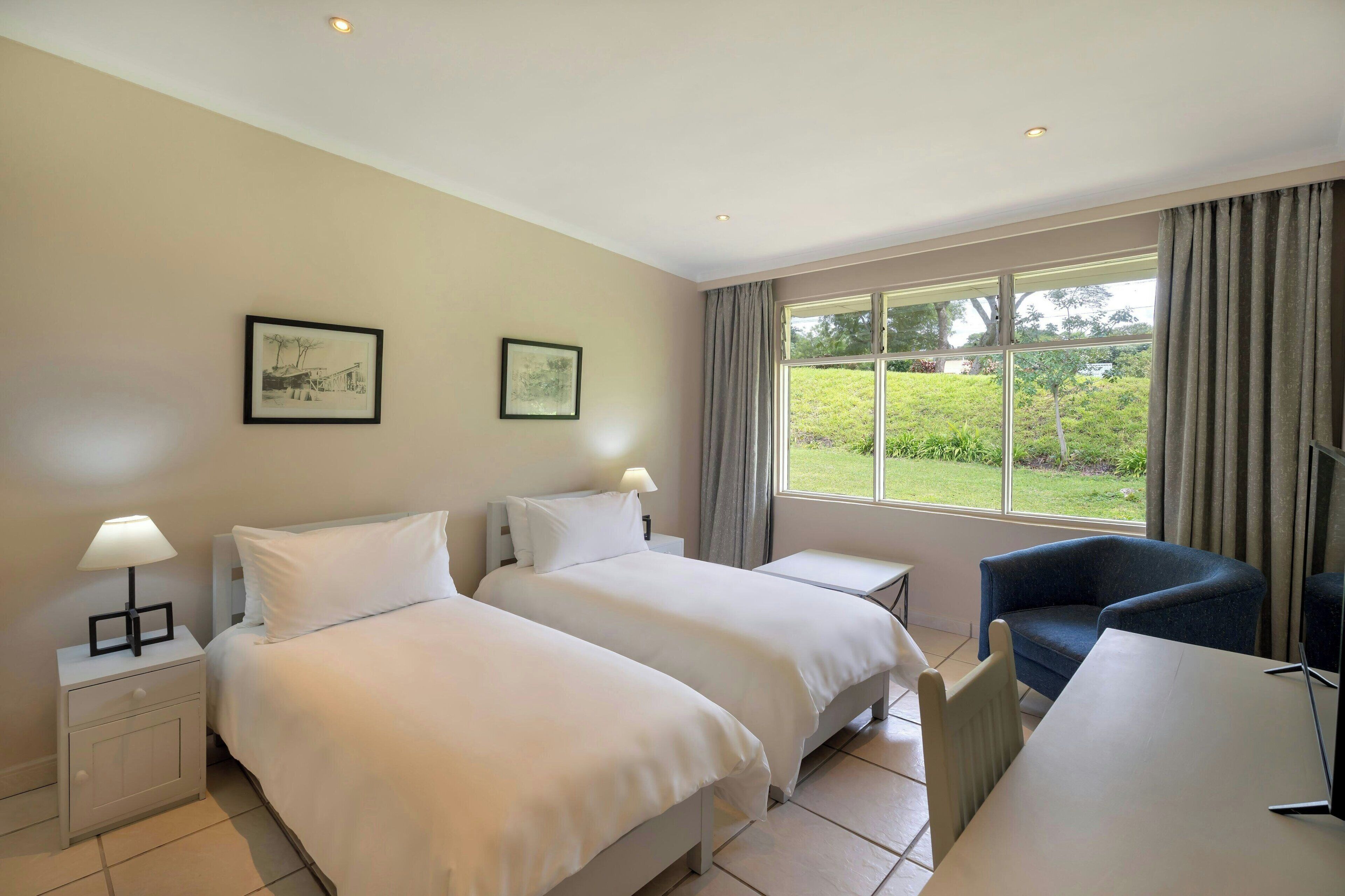 Habitación, 2 camas individuales, vista al jardín | Minibar, caja de seguridad en la habitación y escritorio 
