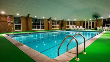 Relax by the pool surrounded by lush surroundings and comfortable lounge chairs.